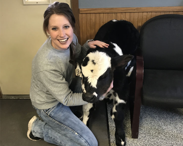 Dr. Lainie Kringen-Scholtz poses for a photo with a young calf